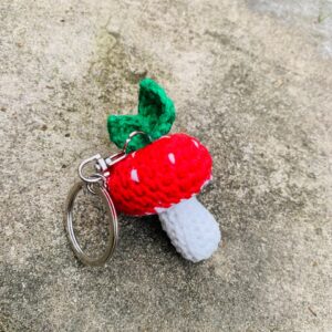 Crochet mushroom keychain handmade with red white and green yarn